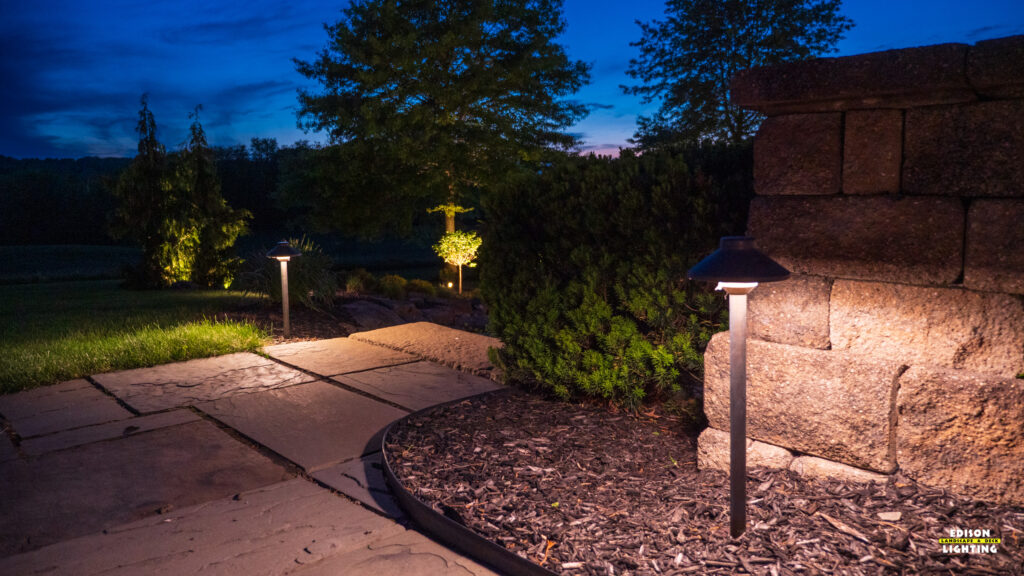 Warm architectural up-lighting on a large luxury home overlooking a beautifully lit backyard patio area