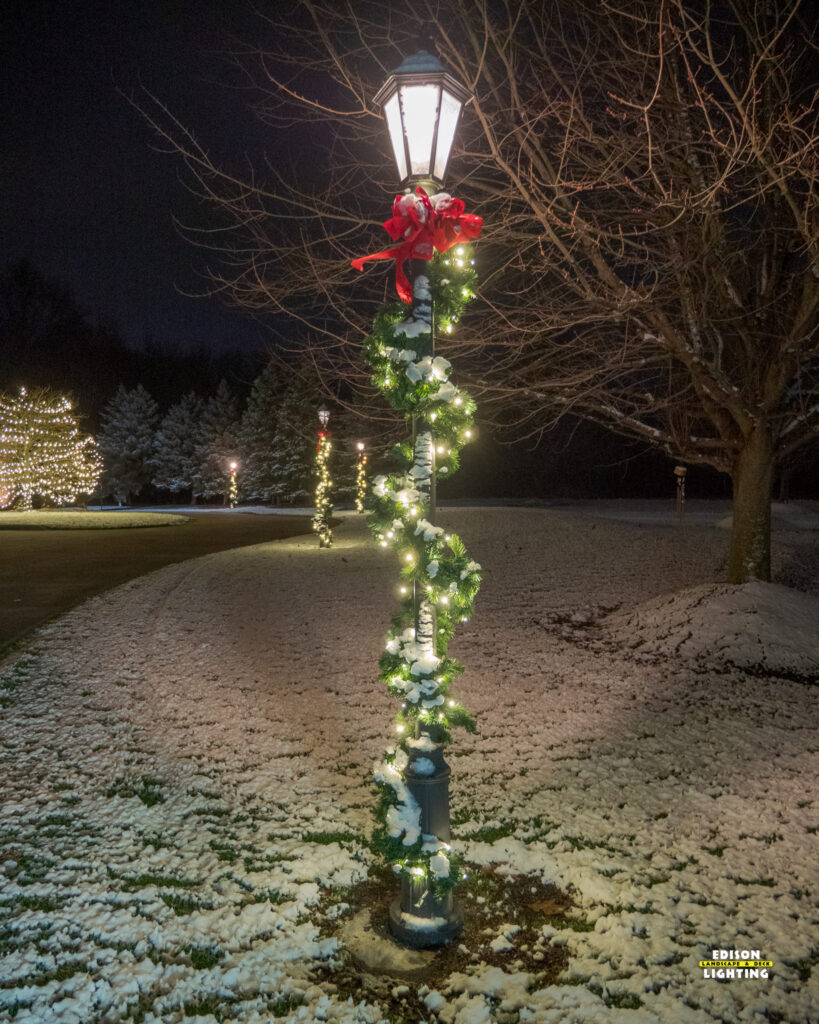 evergreen garland, and a vibrant red bow, a lit lamp post